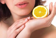 A woman holds a lemon in her palm
