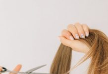 How to Remove a Hair Color Mistake Close-up of scissors cutting long hair indoors, highlighting hairstyling process.